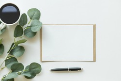 Creative flat lay photo of workspace desk. top view office desk with mock up white paper, coffee, pen, plant branches on white background. Workspace concept. Top view, copy space, mockup, flat lay.