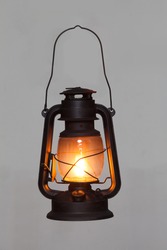 old vintage rusty kerosene black lamp isoleted on gray background. Glass oil lamp. Storm lantern. object vintage concept