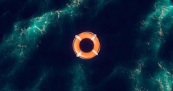 Life buoy. Life buoy in water. Top view of lifebuoy. Life ring floating in a sea. Life preserver in sea. Top view of rescue ring. Rescue ring. Safety ring.