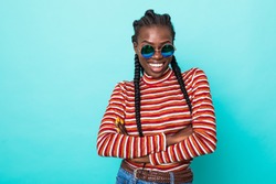 Colorful portrait of amazing woman in red shirt with afro hairstyle looking on camera with smile isolated over blue background