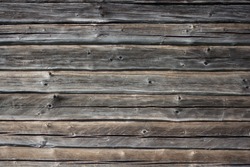 Wooden wall with gray and brown bars. Texture old wood is used in a design, furniture making and construction. Wood is trendy. Dry wood. Wood is a common material in a construction. Old bars with crac