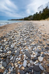 Stones scattered on sandy beach along Lake Michigan shoreline.