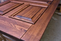 Wood door manufacturing process. Door leaf, painted in dark color. Woodworking and carpentry production. Furniture manufacture. Close-up