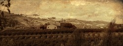 Landscape of the Marche countryside with cottage, cultivated fields and hills in the background, sepia and antiqued effect