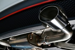 Sportive mufflers. Oval or round Car Exhaust Tailpipe chromed made of stainless steel on powerful sport car bumper. Exhaust silencer, metal fittings and pipes for the muffler