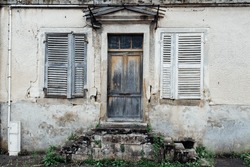 Old abandoned French country house. Rural exodus. Facade of old village house. Haute-Saône house. Closed house. Shutters and doors closed.