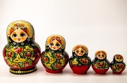 Five Russian wooden dolls in a row from the biggest to the smallest, matryoshka, traditional Russian souvenir, white background, horizontal image, copy space for text 