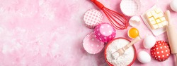 Baking background. Food ingredients for baking flour, eggs, sugar on pink background flat lay. Baking or cooking cakes or muffins. Long format with copy space. Top view