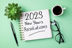 New year resolutions 2023 on desk. 2023 resolutions list with notebook, coffee cup on table. Goals, resolutions, plan, action, checklist concept. New Year 2023 template, copy space
