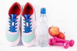 Sport background for fitness, healthy lifestyle, exercise, diet, healthy eating concept. Motivation sport card with sport equipment shoes, dumbbells, fruit and water bottle on white background