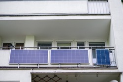 solar panels on the balcony of an apartment in a city block