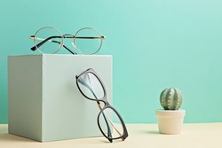 Stylish eyeglasses over pastel  background. Optical store, glasses selection, eye test, vision examination at optician, fashion accessories concept. Front view 
