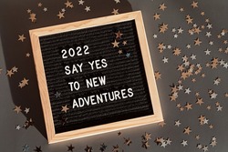 Letter board with text 2022 say yes to new adventures. Motivational quote, new year goals and resolution concept. Flat lay, top view