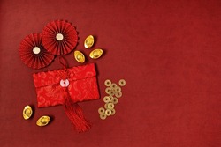 Chinese new year festival decoration over red background. traditional lunar new year red pockets, gold ingots with text meaning fortune, prosperity, wealth. Flat lay, top view