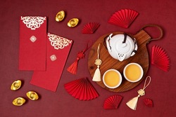 Chinese new year festival decoration. Traditional lunar new year flat lay with green tea, red paper fans, cherry blossom. Top view