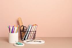 Desktop organizer with school stationary and office supplies over pastel background. Back to school, home office, begining of studies concept