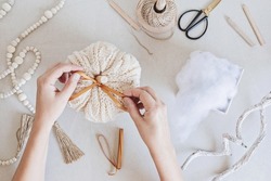 Hobby background with handmade knit pumpkins, tools and accessories. DIY, craft decoration for fall and winter holidays. Flat lay, top view