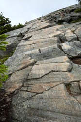 Scoured granite bedrock with glacial striations and a series of glacial grooves, as well as scratches from snow machine treads near the summit of Mt. Kearsarge in Wilmot, New Hampshire.