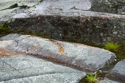 Scoured granite bedrock, with glacial striations and a large, wet groove, on the bald summit of Mt. Kearsarge in Wilmot, New Hampshire.