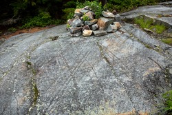 Scoured granite bedrock, with glacial striations and grooves, and a rock cairn at the bald summit of Mt. Kearsarge in Wilmot, New Hampshire.