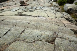 Scoured granite bedrock, with glacial striations and grooves, and a rock cairn in a hiking trail at the summit of Mt. Kearsarge in Wilmot, New Hampshire.
