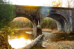 Stone arch Railroad bridge over the West Branch of the Westfield River, along the Keystone Arch Bridges Trail near Chester, Massachusetts, in late autumn.