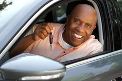 Portrait of a handsome African American man driving his car.
