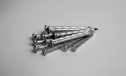 Pile Of Silver Shiny Sharp Metal Nails Closeup Photo Isolated On Grey Background