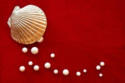 Pearls with golden shell on red velvet