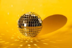 mirror ball on a yellow background, glare from a mirror ball, sun glare on a colored background