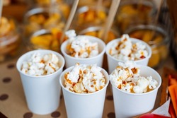 Cups of popcorn with caramel. Crispy sweetness. A bucket of popcorn for a trip to the movies. Five servings of delicious popcorn with caramel. High quality photo