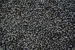 Black plastic chips are shot close-up, granules of polymeric material for the chemical industry, the structure of raw materials in a pile of small plastic. High quality photo