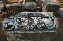 Decorated building fragment with a pattern in the destroyed Antique city of Faselis in the south of Turkey