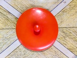 Red plastic glass lid on the wooden tabel.