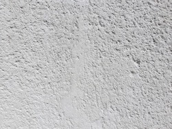 Close up on a painted wall with rough and uneven surface, background texture