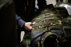 A man is inspecting a bulletproof military vest