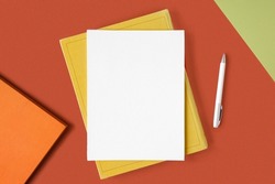 Blank canvas sheet with pen on red orange background, office supplies on table. Top view, flat lay, copy space. Net white page. Card mockup. Elegant layout, template. Soft shadow. Minimal design.