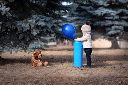 A little boy inflates a balloon with helium. Baby and his friend bear in the park. Winnie the Pooh. Spring walk of a child with a toy. Childhood. Based on a fairy tale. helium tank