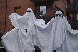 Funny Halloween Kid Concept, 3 little kids with white dressed costume halloween ghost scary with sunglasses, Ghost costume for Halloween concept.  A ghost of a child under a white sheet.