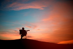 Silhouette of asia young man with playing acoustic guitar, sunset background