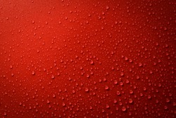 Drops of water on red and black surface. Macro photo, drop, shadow plastic base.