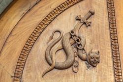 Devil snake symbol. Fantasy magic creature on an old door, 12th Century Abbey, Italy.