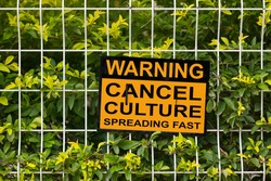 Black and yellow warning sign on a fence stating 