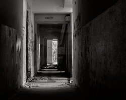 Ghost of a man in an abandoned building. Silhouette in the abandoned building. Ghost corridor. Black and white photo. 