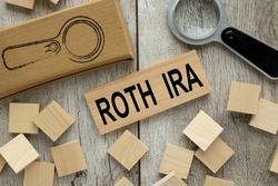 ROTH IRA wooden block on a light table. magnifier and wooden cubes.