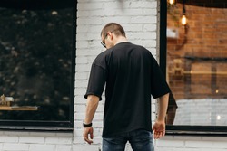 Man wearing black blank t-shirt with space for your logo or design. Mock up