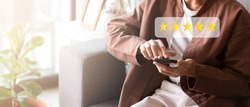Customer pressing on smartphone with five stars icon for feedback review satisfaction service