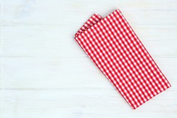 Red towel over wooden kitchen table. View from above with copy space