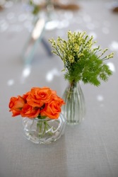 beautiful banquet table flower arrangement with roses and flowers in glass vase with blur background
