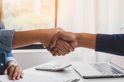 Successful young asian woman, man  partnership, team handshake together at office after project done, good deal. Happy business people, worker meeting, shaking hands concept.
